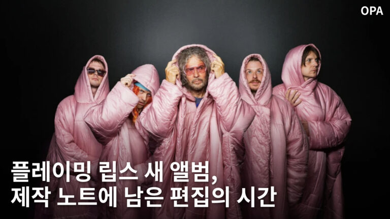 분홍색 후드 의상을 입고 나란히 선 다섯 명의 밴드 멤버